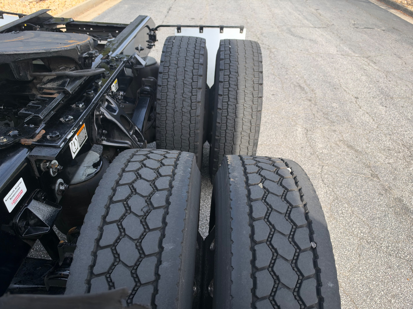 Truck tractor chassis with dual rear axles and large tread tires visible undercarriage.