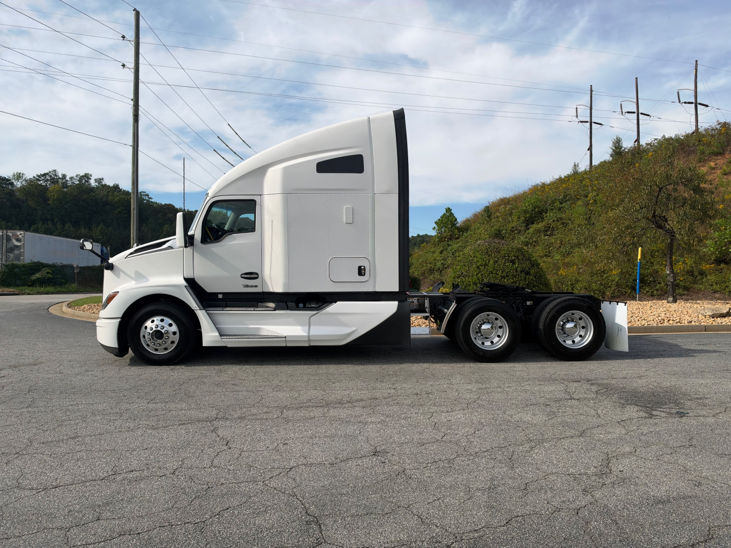 Kenworth T680 tractor unit side view showing sleeper cab and chassis with three rear axles, white paint, no trailer attached.