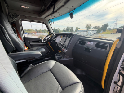 Kenworth T680 truck cabin interior view from the driver's seat showing dashboard, steering wheel, and seating area.