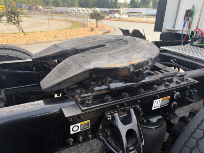Kenworth truck fifth wheel and rear semi-truck chassis showing mounting plate and hydraulic components.