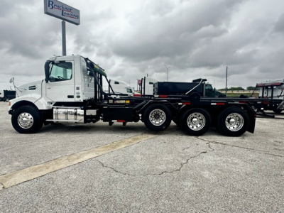 Volvo VHD 2020 roll-off truck side view showing white cab, heavy-duty flatbed trailer, rear dual-axle configuration, and VIN/stock details not visible on image.
