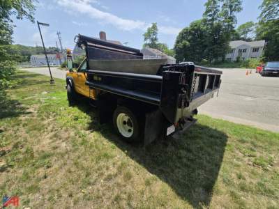 GMC Sierra Classic 3500 dump truck side rear view showing dump bed and yellow cab.
