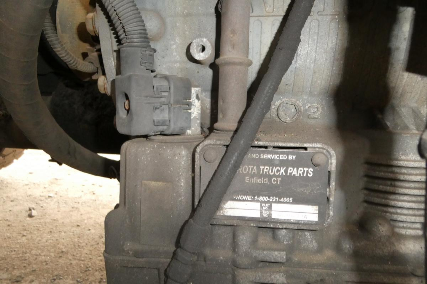 Engine bay area showing a nameplate with 'TOYOTA TRUCK PARTS' and contact details, plus wiring harness and sensor wiring.