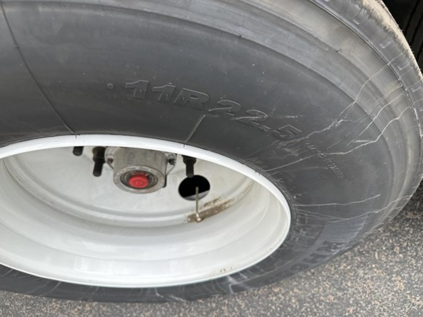 Tire and wheel assembly of a new 2027 Timpte Super Hopper trailer showing a white rim and tire with a hub cap.