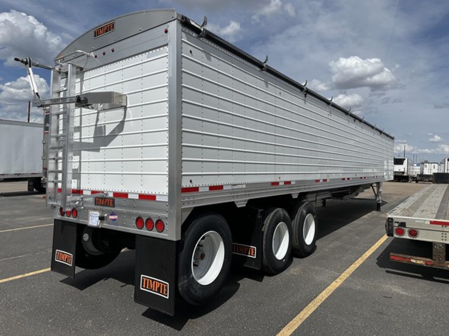 Timpte Super Hopper trailer showing side and rear with white panels and black wheels.