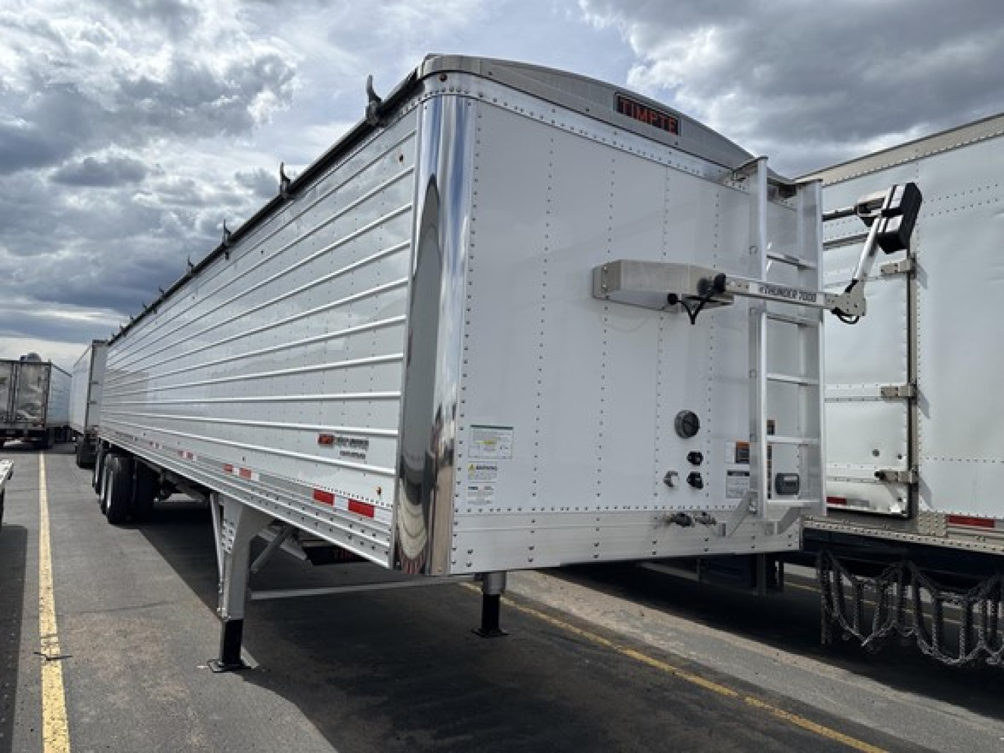 Timpte Super Hopper trailer side and rear showing aluminum grain trailer with landing gear and rear latch, side view