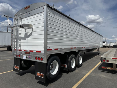Timpte Super Hopper trailer showing side and rear with white panels and black wheels.