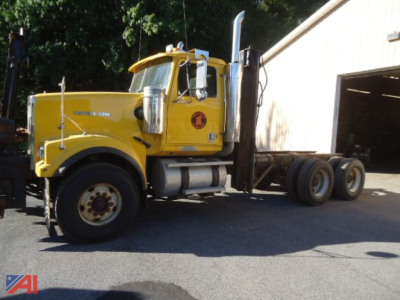 Yellow Western Star 4900 cab and chassis truck side view showing front grille, exhaust stack, and dual rear axles.