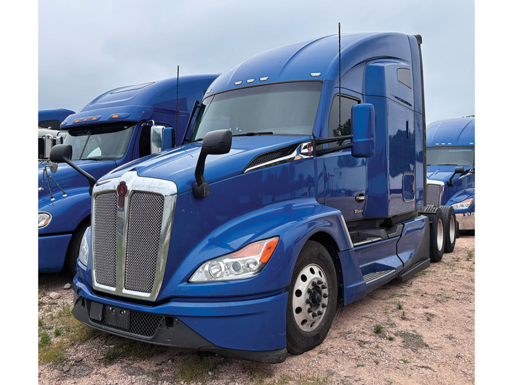 Kenworth T680 Next Gen blue tractor-trailer truck front-left view showing chrome grille and headlights.