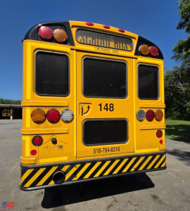 Back view of a yellow 2018 International CE 300 school bus, showing rear doors, lights, black-and-yellow hazard bumper, and bus number 148.