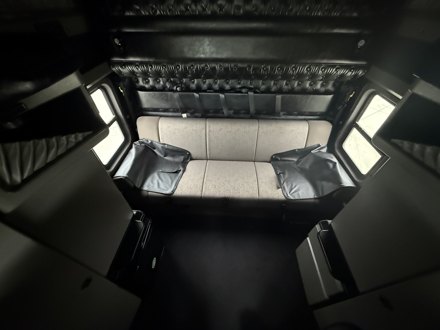 Kenworth W900L truck interior cab area showing sleeper bench seat and control panels