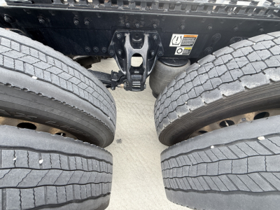 Kenworth W900L rear view showing dual rear axles and tires with inner frame, hitch and undercarriage components.