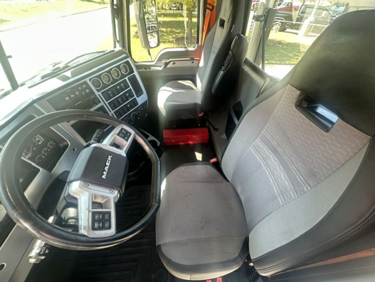 Interior of a 2023 Mack Anthem 64T truck cab showing steering wheel, dashboard, and front seats.