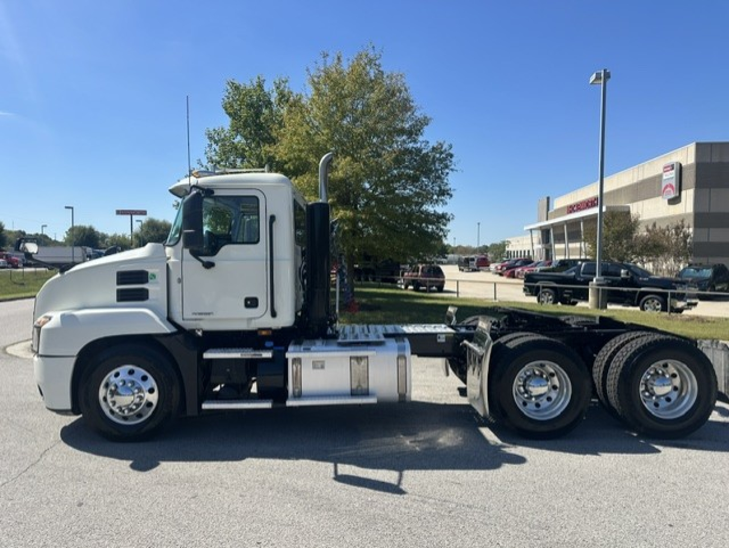 Truck side view showing 2023 Mack Anthem 64T cab and chassis with dual rear axles and fuel tank.