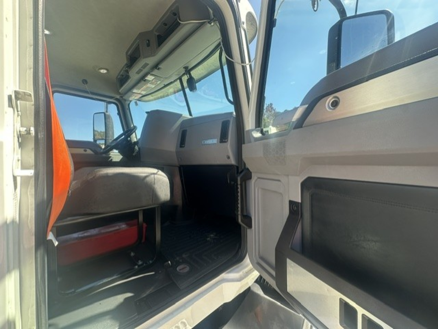 Truck cab interior showing driver door area and dashboard of a Mack ANTHEM 64T daycab.