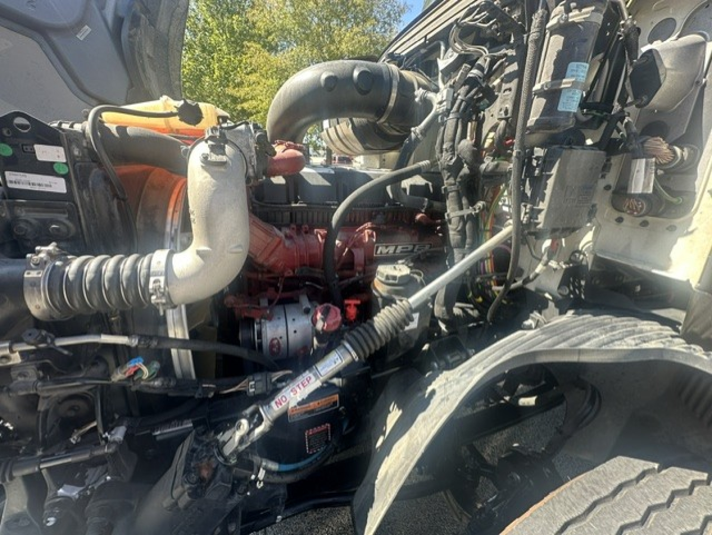 Mack ANTHEM 64T engine bay showing turbocharger and intercooler piping with red engine block and surrounding hoses.