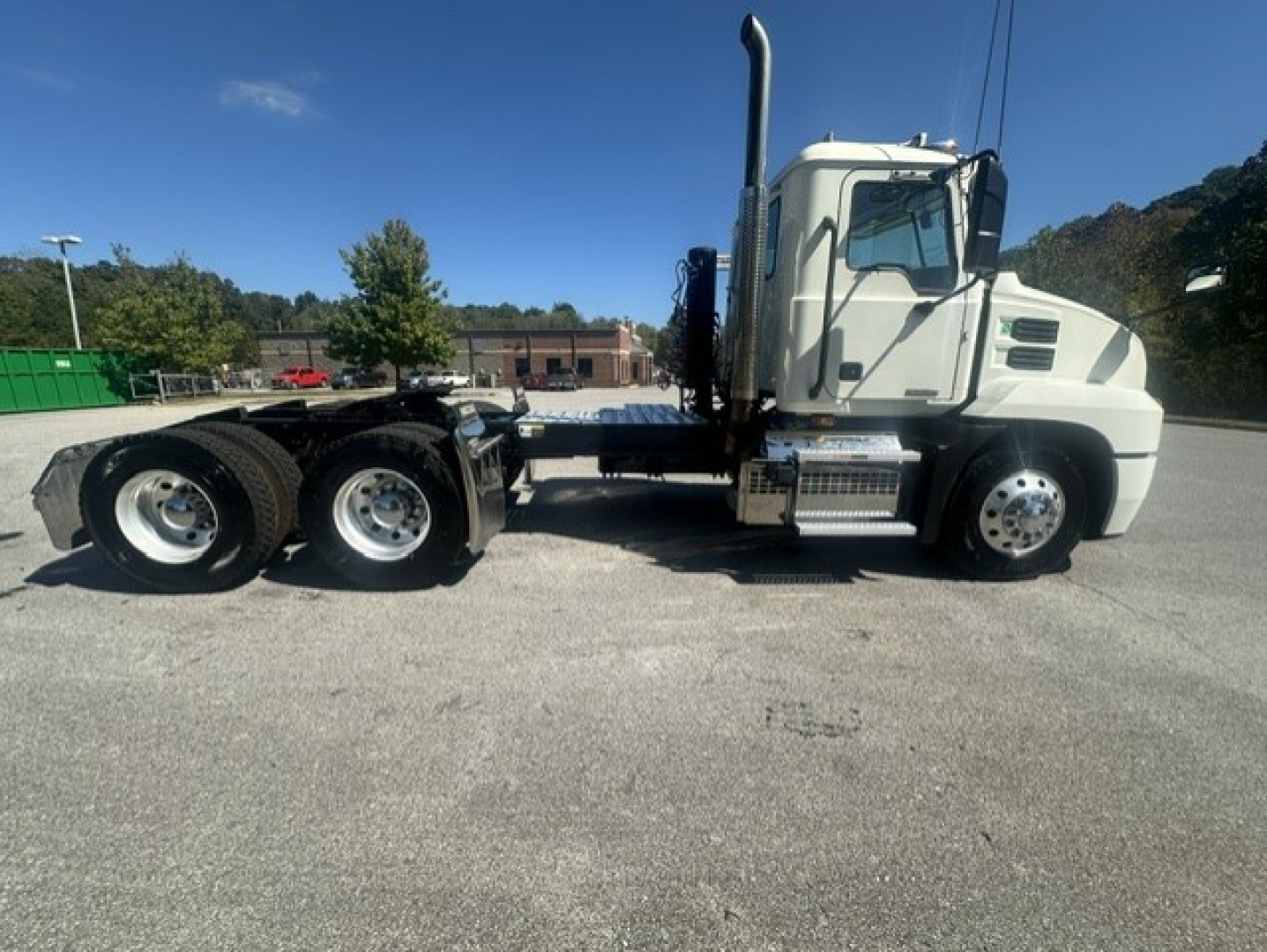 Truck side view showing Mack ANTHEM 64T chassis with dual rear axles and sleeper cab; chrome steps, exhaust stack, fuel tanks visible.