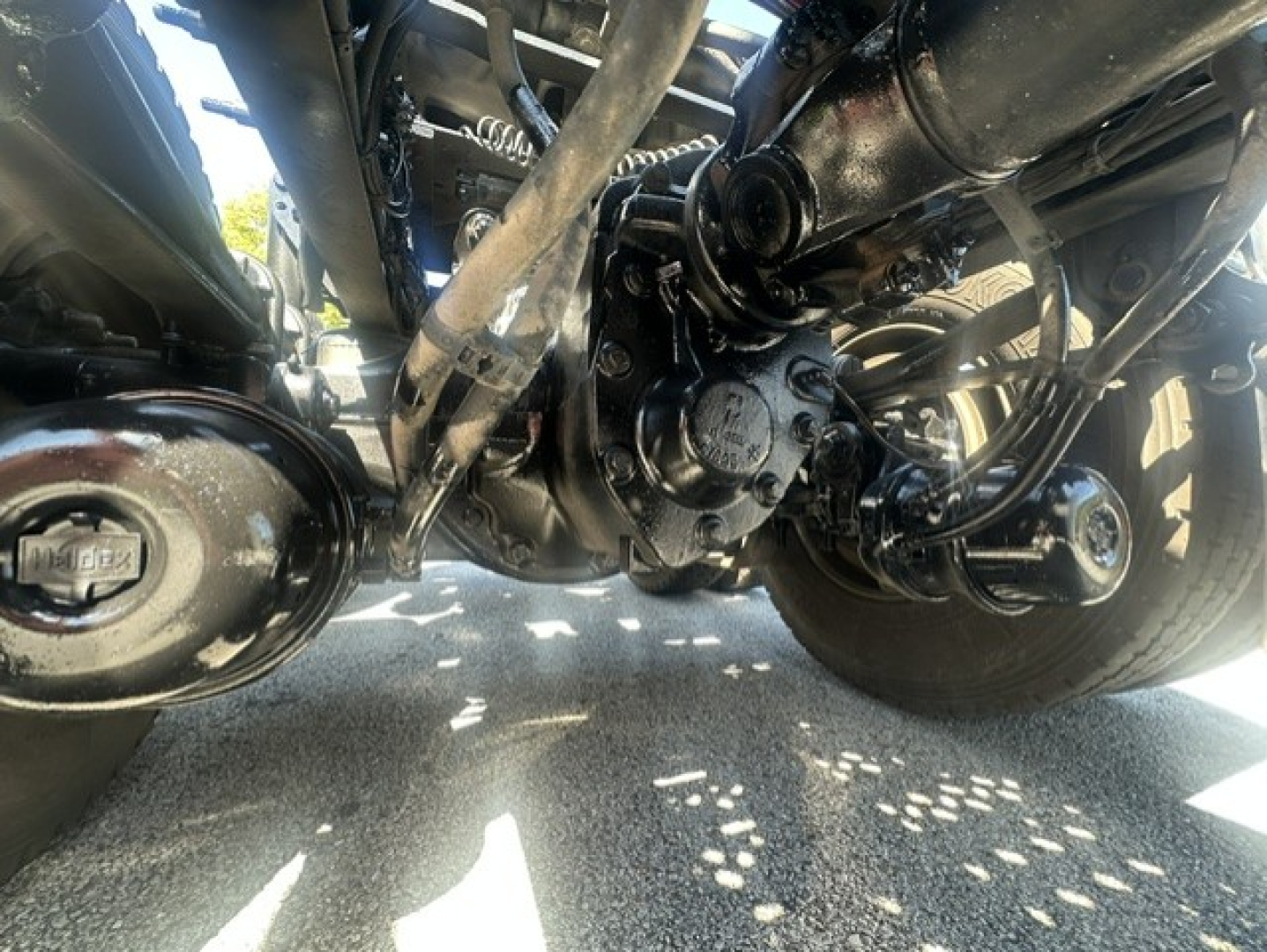 Bottom view of a Mack ANTHEM 64T chassis showing undercarriage components and driveshafts with a central differential and suspension parts.