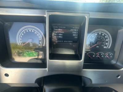Dashboard of a Mack truck showing gauges and a central digital display with mileage and engine hours.