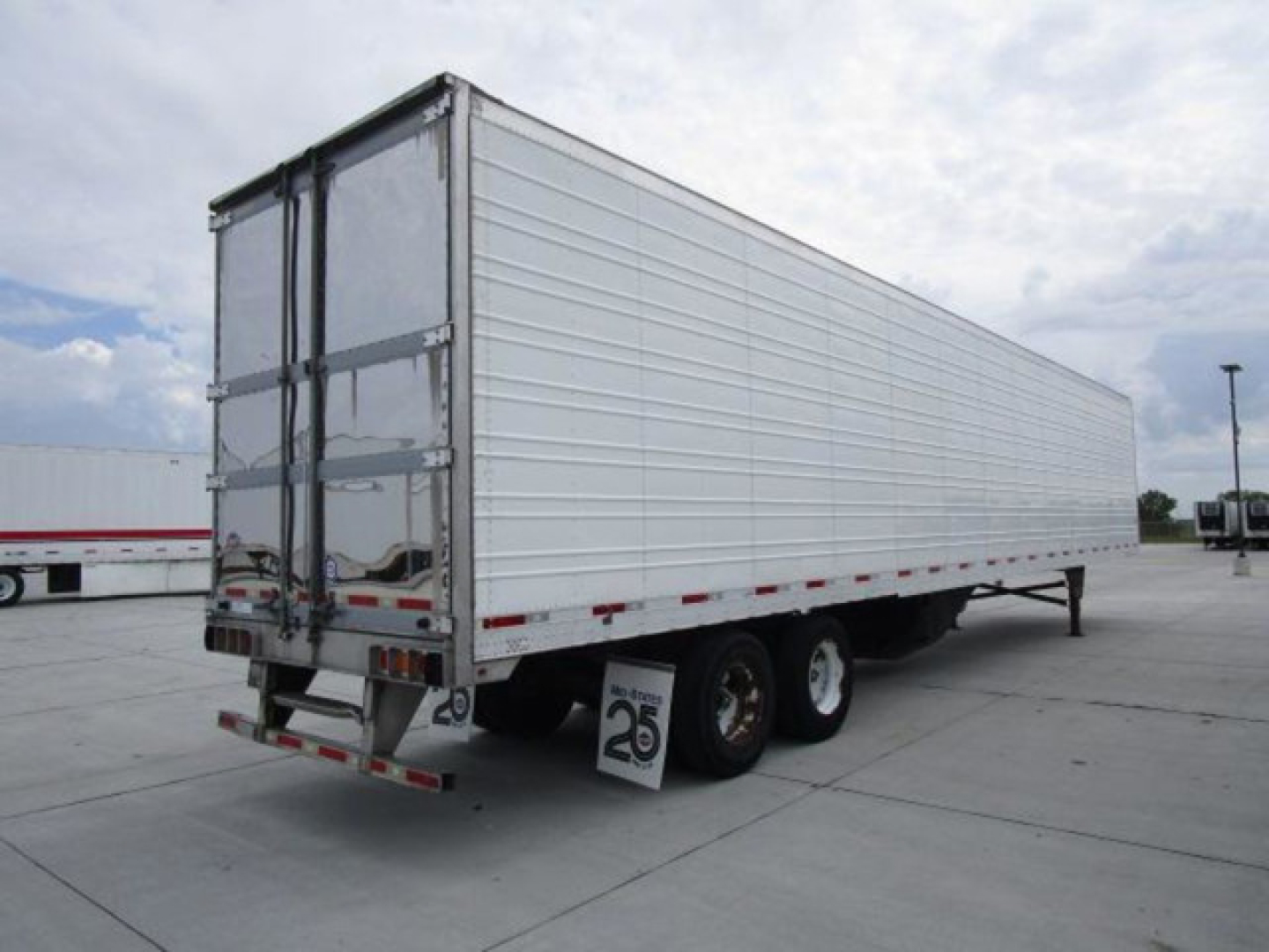 Trailer showing a 2019 Utility refrigerated trailer with white aluminum sides, dual rear doors, and triple axle wheels.