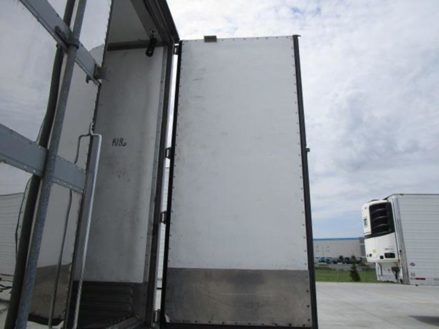 Trailer interior entry door and wall of a 2019 utility reefer trailer showing metal panels and vertical frame.