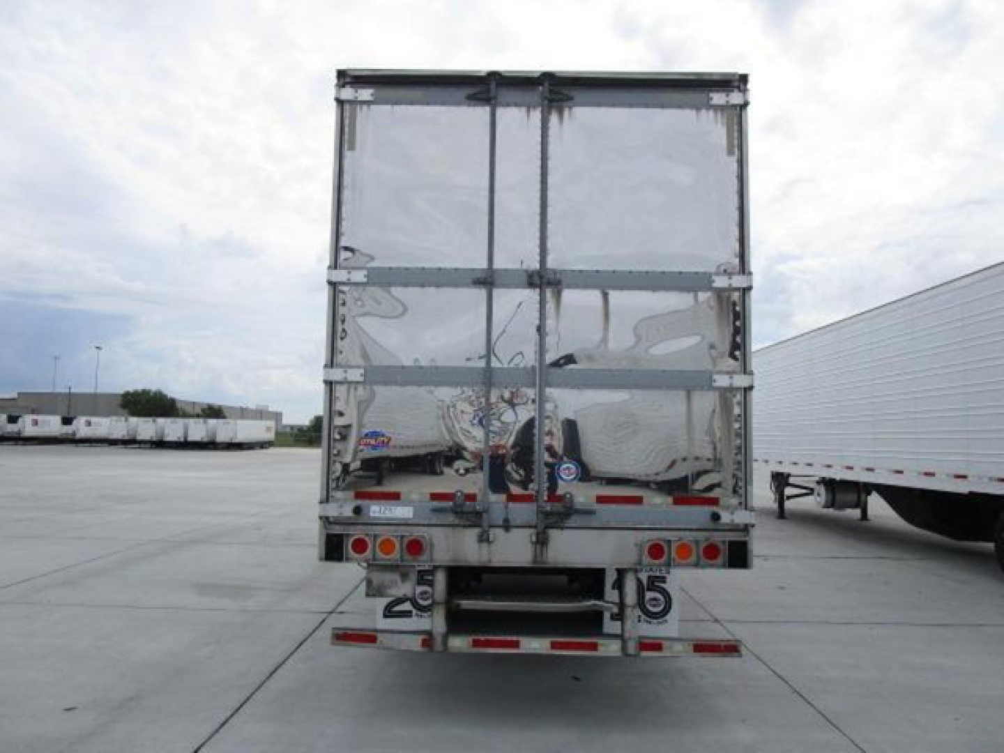 Rear view of a 2019 Utility refrigerated trailer with reflective doors, dual rear doors, and bumper with lights and reflectors.