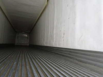 Trailer interior showing empty cargo area with ribbed floor and vertical walls in a refrigerated trailer.