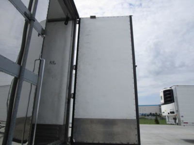 Trailer interior entry door and wall of a 2019 utility reefer trailer showing metal panels and vertical frame.