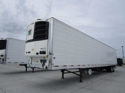 Trailer with a front refrigeration unit showing a white Thermo King reefer on a long box trailer in a parking lot.