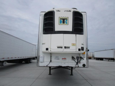 Front view of a refrigerated trailer with a TT logo on the cooler unit, black vents, and dual tandem landing gear visible.