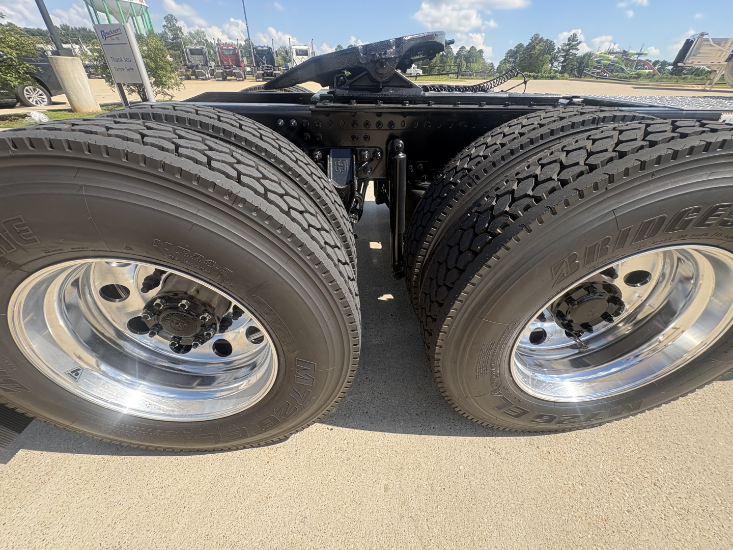Mack PI64T truck rear view showing dual rear axles with Bridgestone tires and polished chrome wheels.