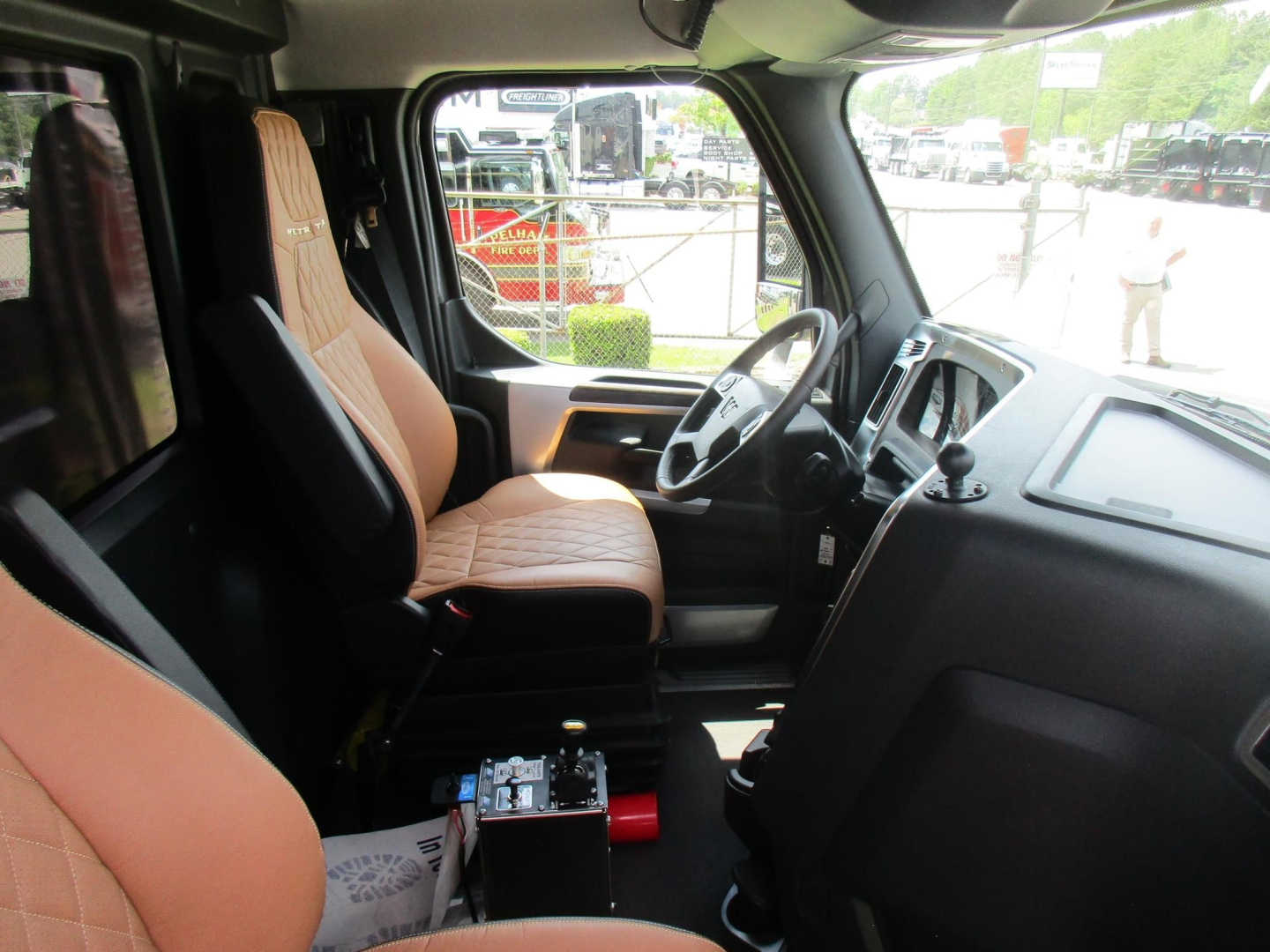 Interior of new Western Star 49X dump truck cab showing driver seat and dashboard with steering wheel.