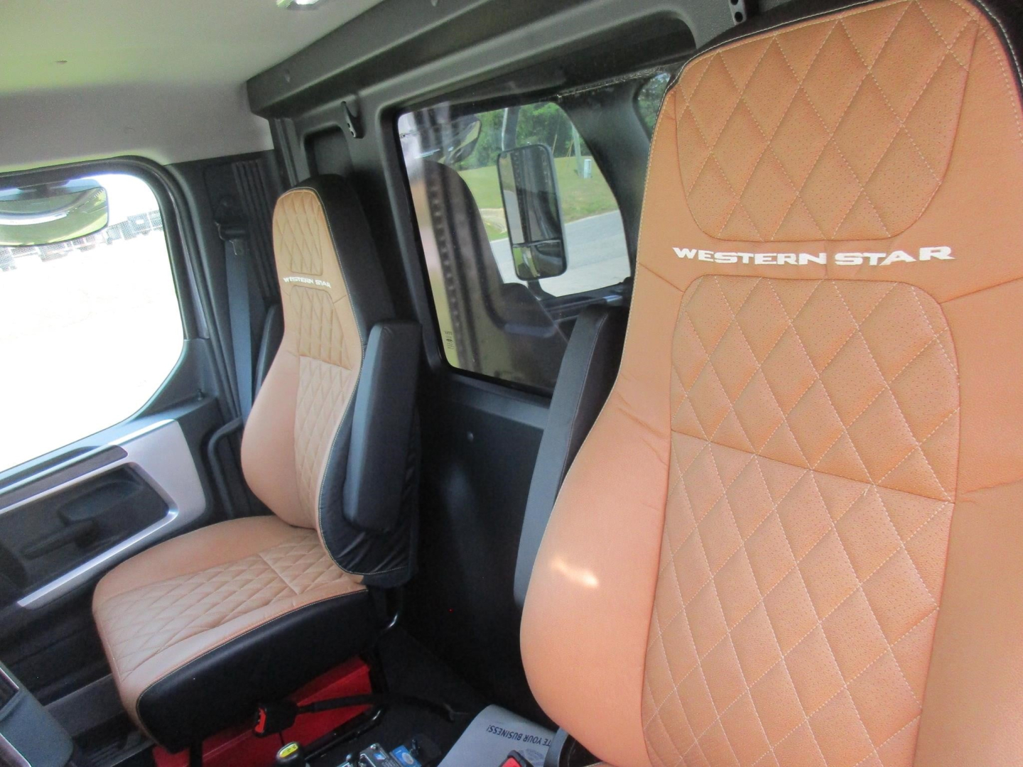 Western Star interior showing tan quilted seats with Western Star logo, front cab seating.
