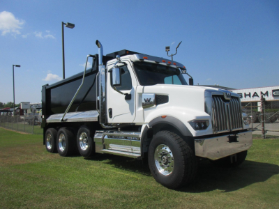 White Western Star 49X dump truck with black dump body, three rear axles, chrome front bumper, and large grille; VIN tag and stock number not visible.
