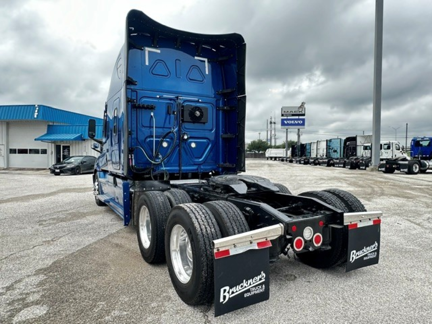 Freightliner Cascadia 126 tractor rear view showing dual axles and mud flaps with Bruckner’s logo.