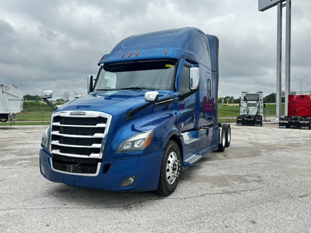 Truck cab front-right view of a blue Freightliner Cascadia 126 sleeper, with chrome grille and side mirrors.