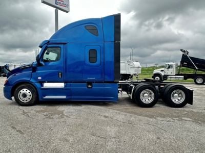  Freightliner Cascadia 126 sleeper cab side view showing blue tractor, dual rear axles, and extendable trailer hitch area.