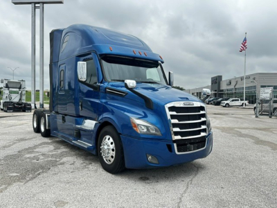 Blue 2022 Freightliner Cascadia 126 tractor-trailer view showing front grille and cab with sleeper