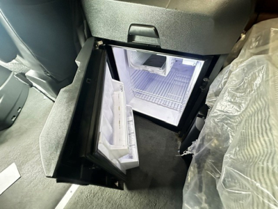 Freightliner Cascadia 126 cab interior showing open center console storage with small fridge/freezer visible inside.