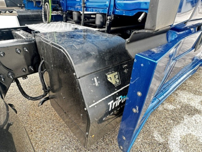 Freightliner Cascadia 126 truck side view showing TripPak fuel tank/compartment with black protective cover and blue cab