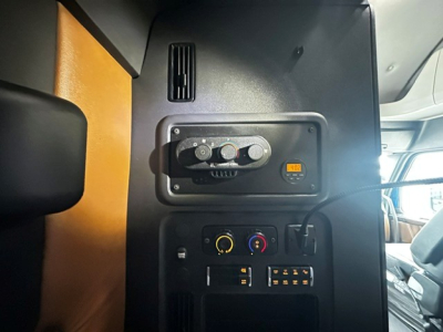 Dashboard panel in Freightliner Cascadia showing control dials and connector panel.