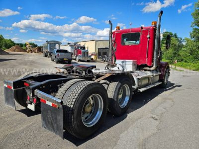 Freightliner Coronado SD tractor showing rear chassis and dual rear axles with mud flaps and red cab.