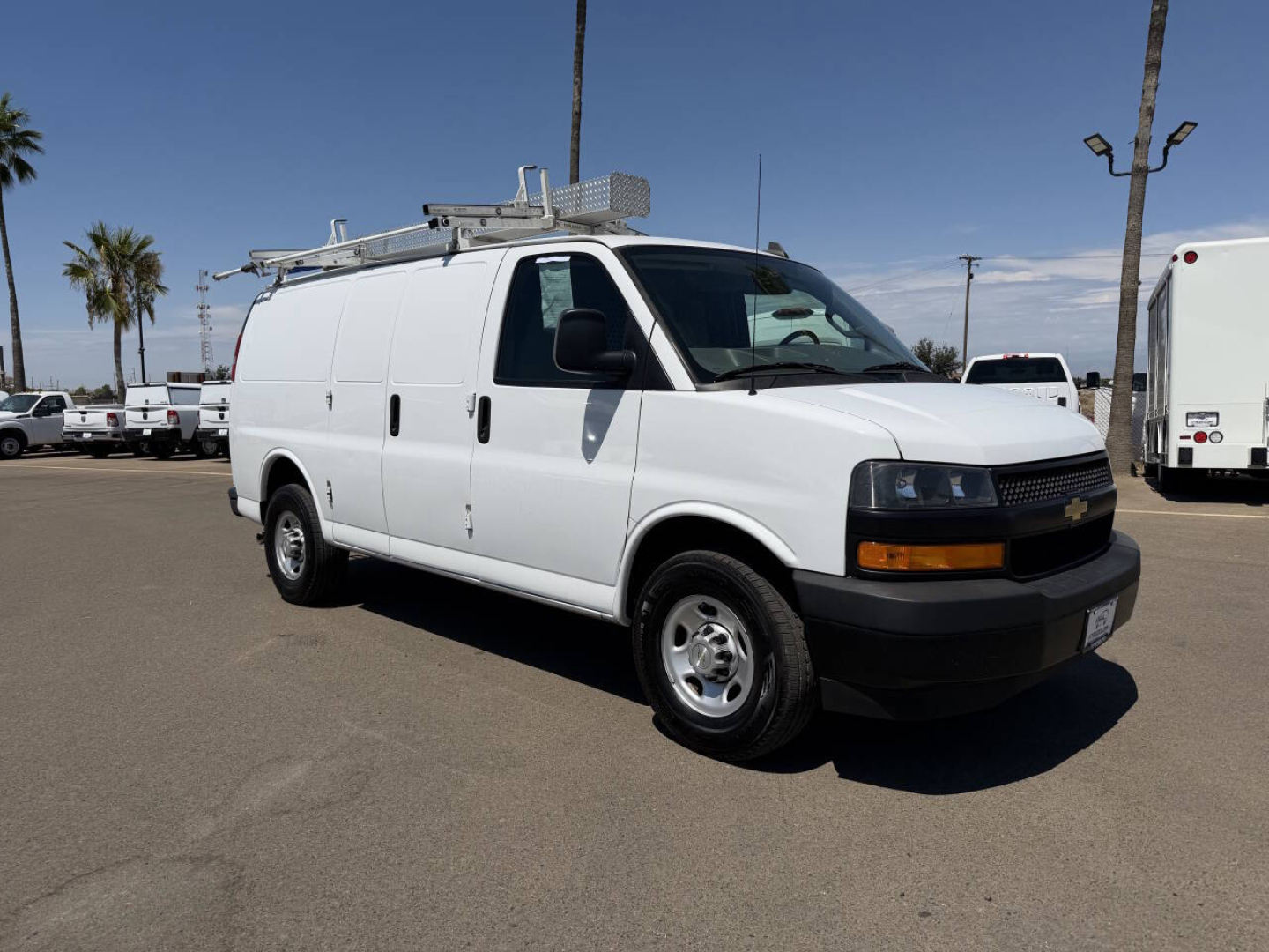 Chevrolet Express utility van side view showing ladder rack, front bumper, and Chevrolet badge.