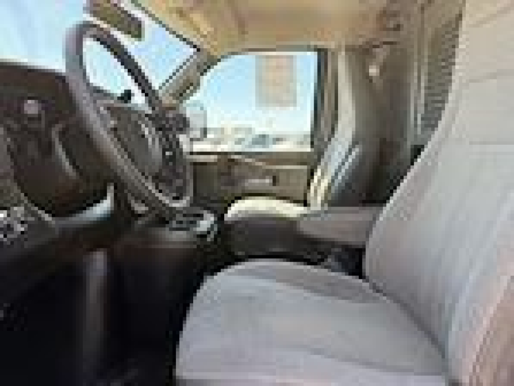 Chevrolet Express cargo van interior view showing front seats, steering wheel, and dashboard.