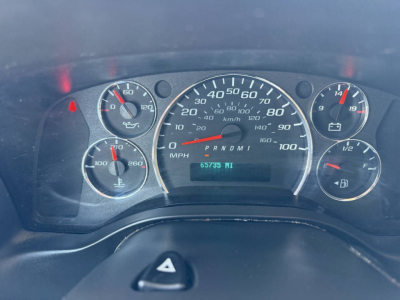 Dashboard of a Chevrolet Express van showing speedometer, tachometer, fuel gauge, and warning lights. Odometer reads 67,535 miles.