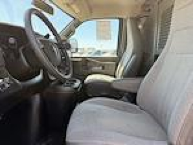 Chevrolet Express cargo van interior view showing front seats, steering wheel, and dashboard.