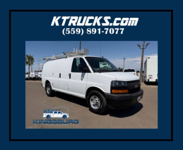 Chevrolet Express cargo van in service condition with white exterior, headlights, front grille, and ladder rack on top.