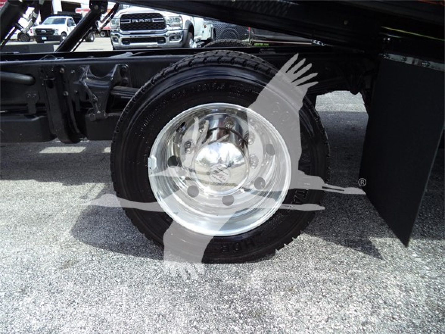 Truck wheel and cherry picker undercarriage visible with Silverado-style wheel.