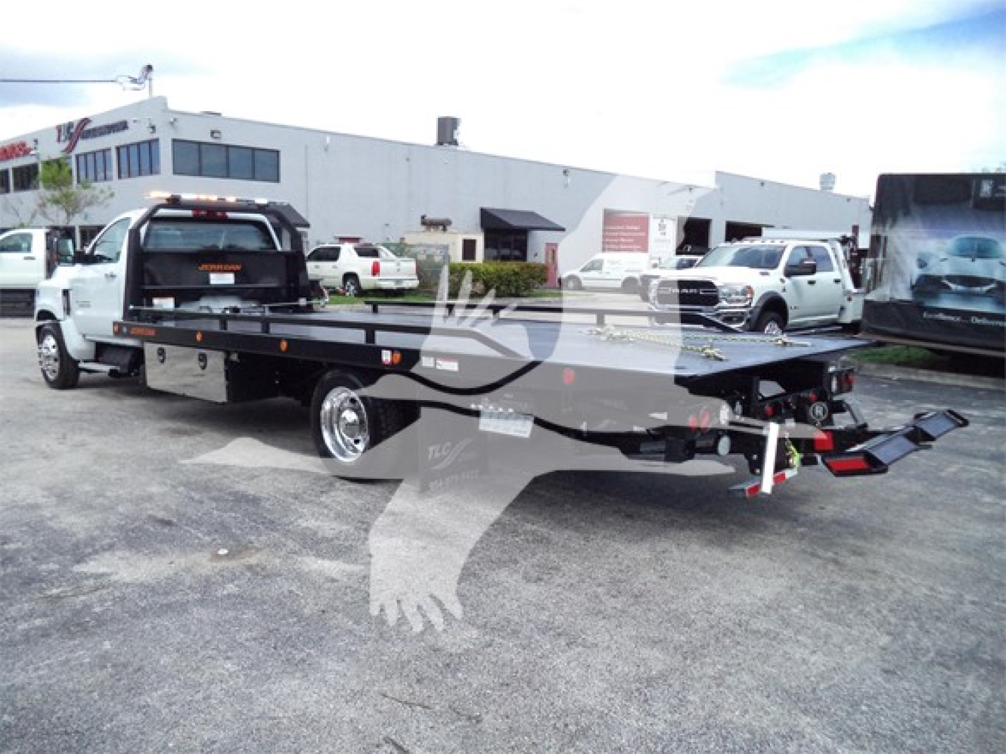 Chevrolet Silverado 6500HD rollback tow truck viewed from side rear showing flatbed and towing equipment.