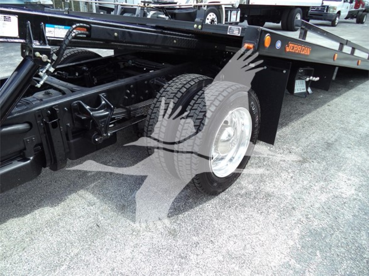 Truck rear wheel and tow truck bed showing Chevrolet Silverado 6500HD branding and wheel well.